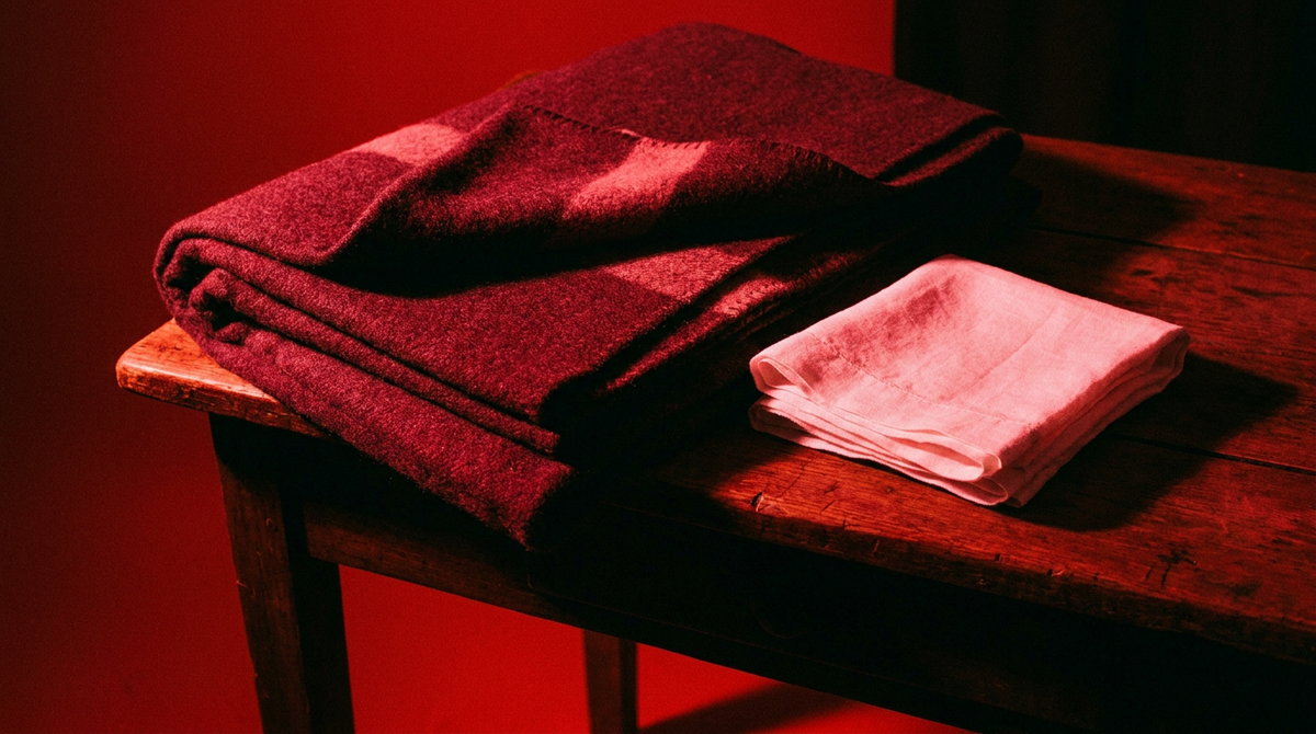 Opgevouwen deken en schone doek op een donkere tafel in rood licht