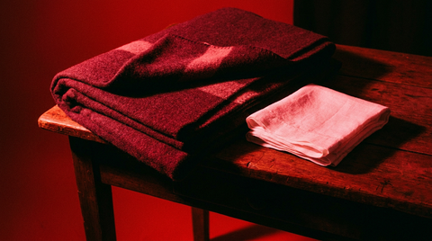 Opgevouwen deken en schone doek op een donkere tafel in rood licht