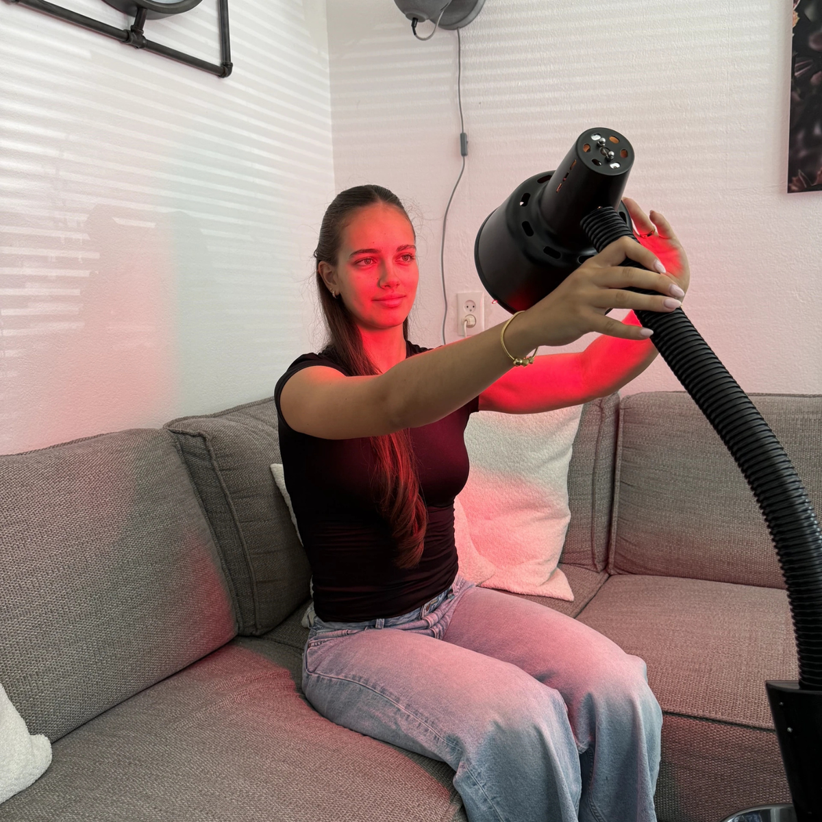 Vrouw stelt de lampkop van de Redlight 160 infraroodlamp met de hand bij