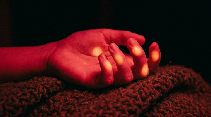 Ontspannen hand op een wollen deken in rood licht