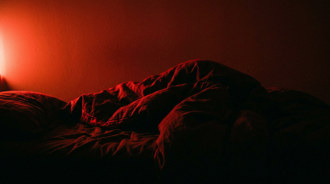 Silhouet van beddengoed in diep rood licht