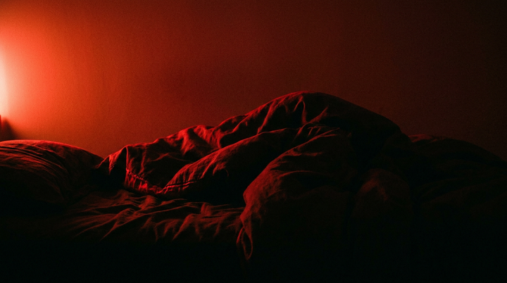 Silhouet van beddengoed in diep rood licht