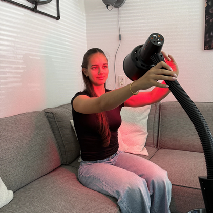 Vrouw stelt de lampkop van de Redlight 160 infraroodlamp met de hand bij